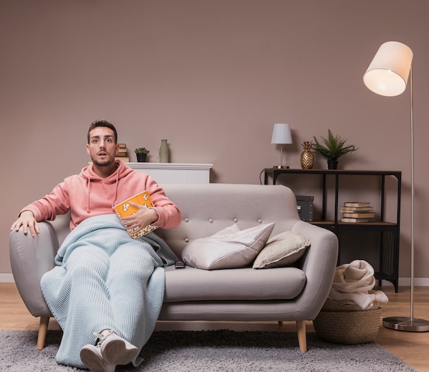 Man with popcorn watching tv Free Photo