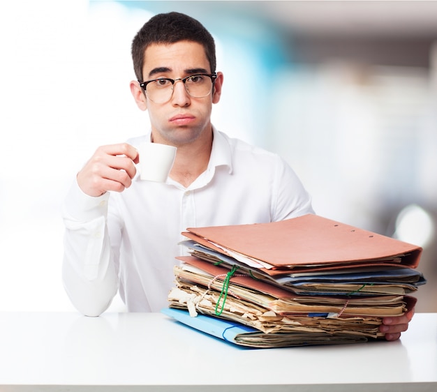 Man with sad face with folders and a cup of coffee Free Photo Man with sad face with folders and a cup of coffee Free Photo
