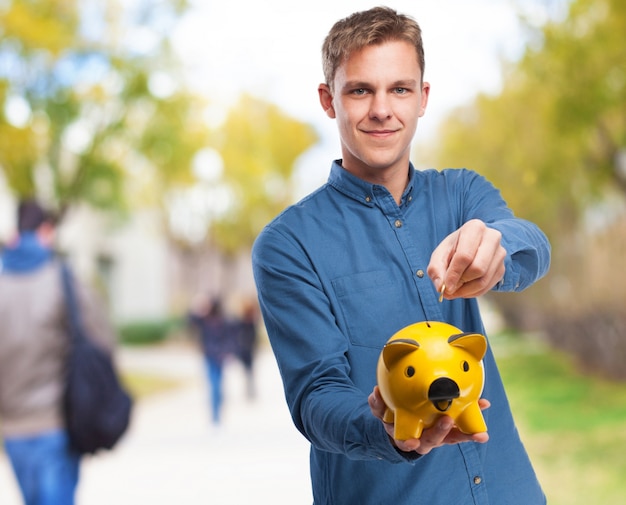 Man with a yellow piggy bank Free Photo