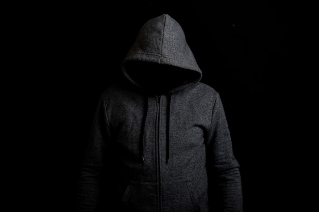 Premium Photo | Man without a face in a hood on a dark background.