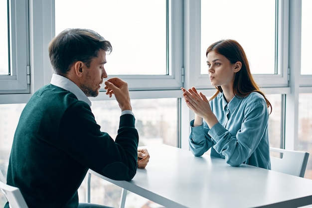 Premium Photo | Man and a woman are sitting at a table talking ...