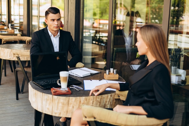 Premium Photo | Man and woman sitting in a cafe during a business ...