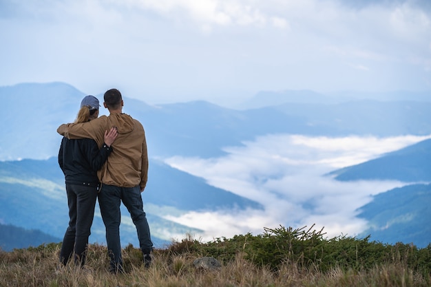 Premium Photo | The man and a woman standing on the mountain landscape ...