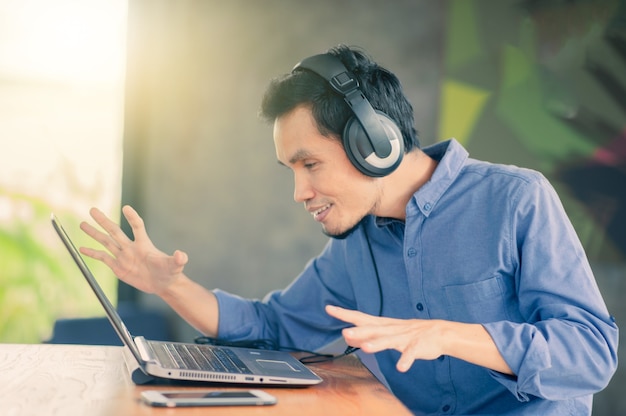 Premium Photo | Man working computer listening music at cafe ...