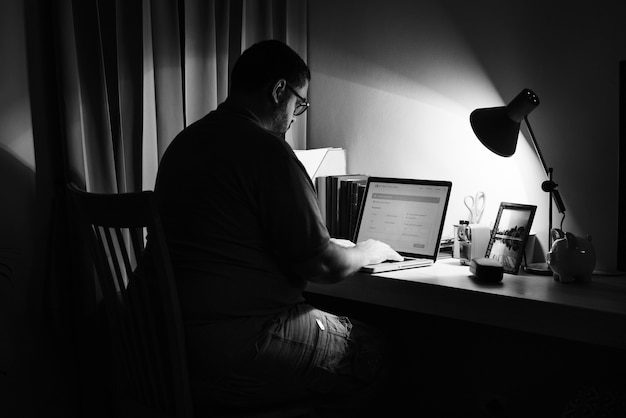 Free Photo Man Working In A Dark Home Office With A Laptop