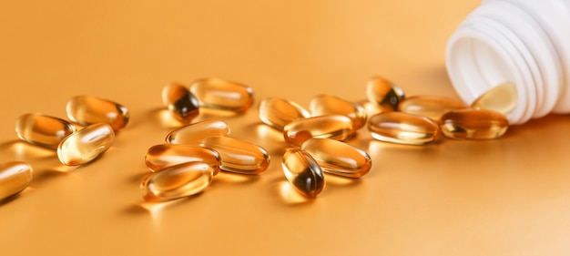 Premium Photo | Many capsules omega 3 on yellow surface