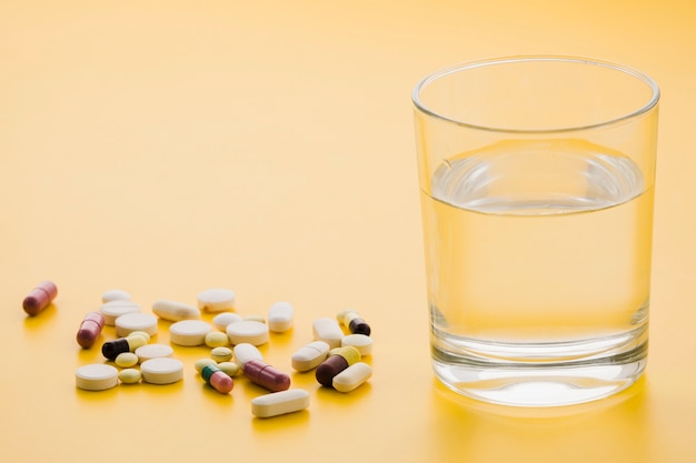 Download Free Photo Many Colorful Pills And Glass Of Water On Yellow Background Yellowimages Mockups