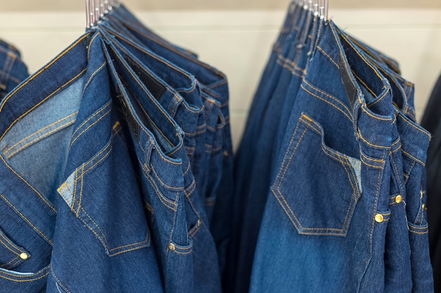 Premium Photo | Many denim jeans hanging on a rack