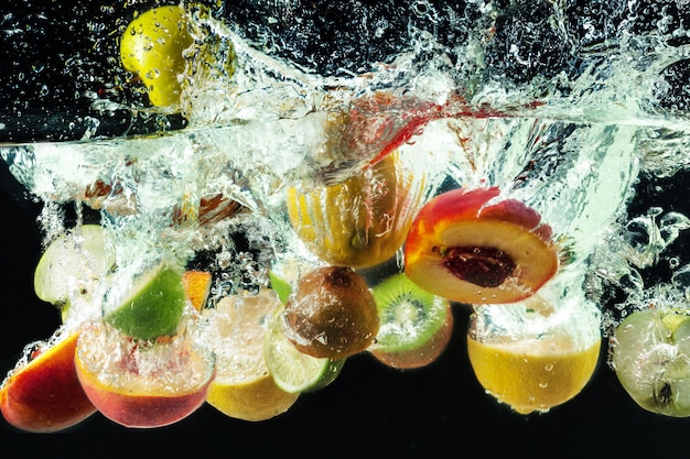 Premium Photo | Many fruits splashes into water