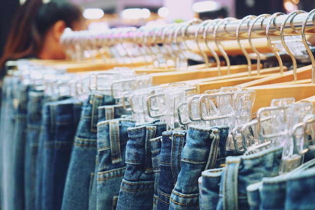 Premium Photo | Many jeans hanging on a rack in a shop