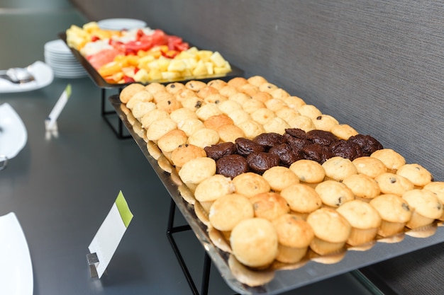 Premium Photo Many Sweet Muffins And Sliced Fruits On A Table On A Coffee Break In The Office