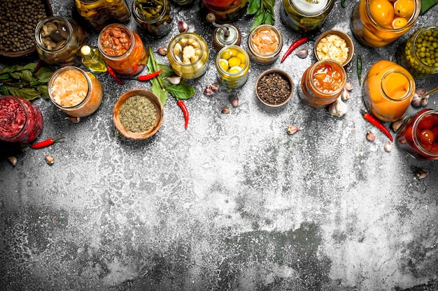  Marinated vegetables with spices in glass jars. on a rustic table. Premium Photo