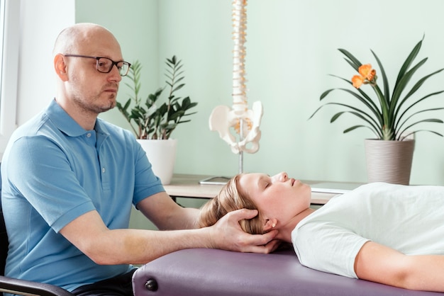 Premium Photo | Massage therapist performing cranial sacral therapy on ...