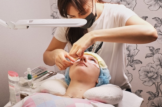 Master eyelash extension at work imposes patches Premium Photo