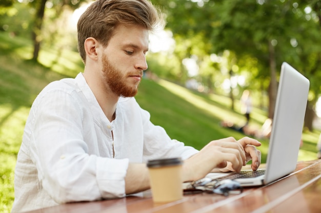 Free Photo | Mature ginger handsome man with laptop computer in the park