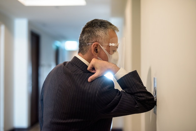 Premium Photo Mature Japanese Businessman With Mask And Face Shield Pressing Elevator Button With Elbow