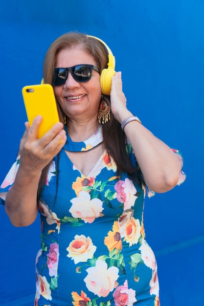 Premium Photo Mature Latina Woman Using Smartphone And Headphones In