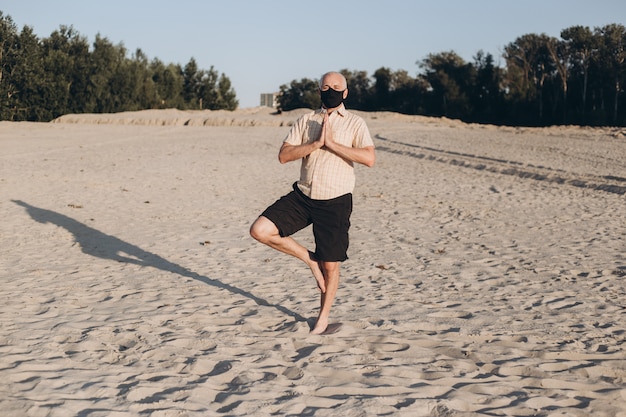 Premium Photo Mature Man Doing Yoga Exercises Man Wearing Protective Mask