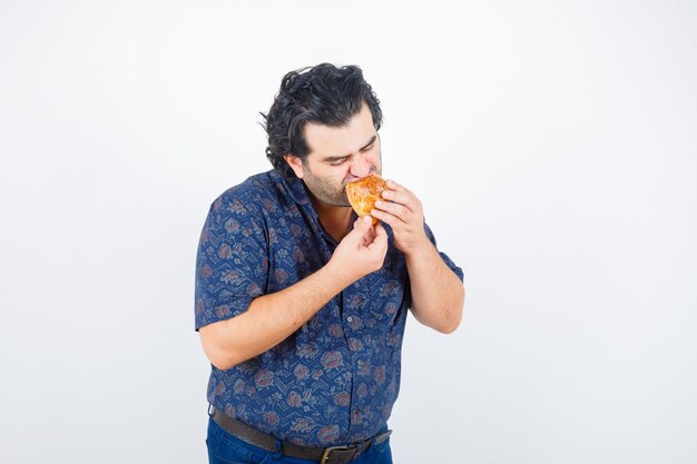 Free Photo Mature Man Eating Pastry Product In Shirt And Looking Delighted Front View