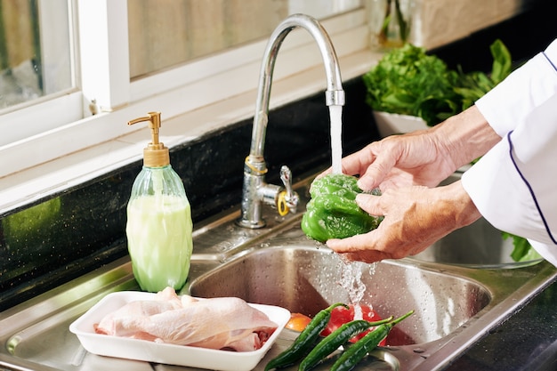 Premium Photo | Mature person rinsing vegetables