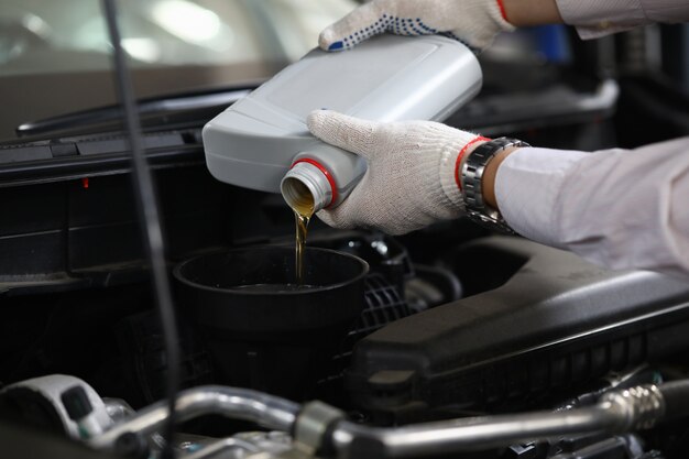 Mechanic adding oil to the car Premium Photo
