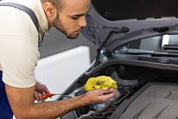 Premium Photo | Mechanic Checking The Engine Oil Level With Dipstick