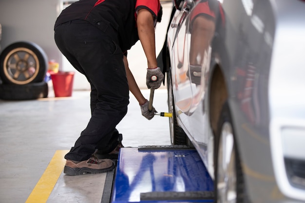 The mechanic is changing the car tires for those who use the tire center. Premium Photo