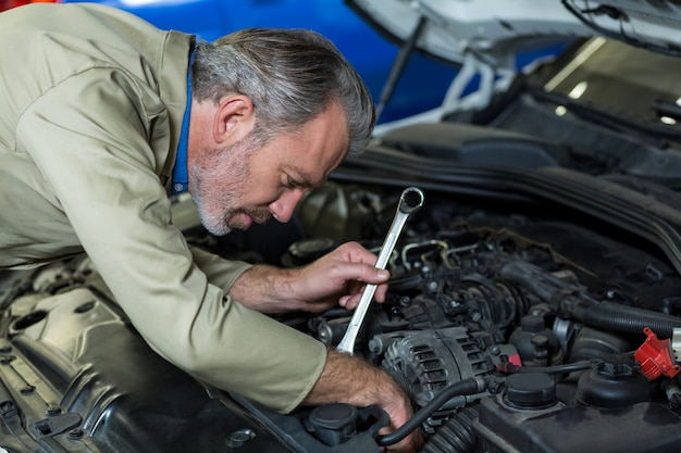 Free Photo | Mechanic servicing a car engine