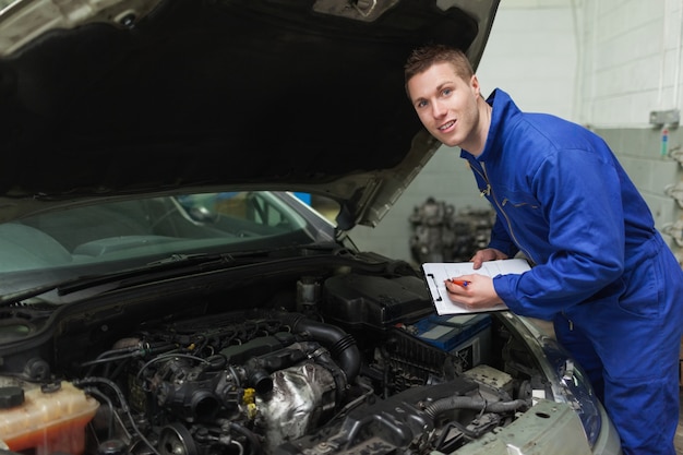 Premium Photo | Mechanic with clipboard by car