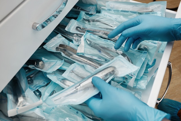 Medical laboratory technician holding a set of sterile disposable instruments Free Photo