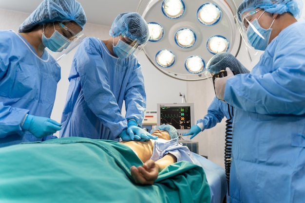 Premium Photo | Medical team in surgical gown help patient to making ...