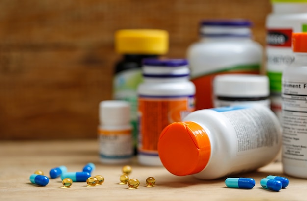 Medicine bottles and tablets on wooden desk Free Photo