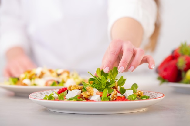 Mediterranean diet salad with feta cheese, grape, nuts, and lettuce. Free Photo