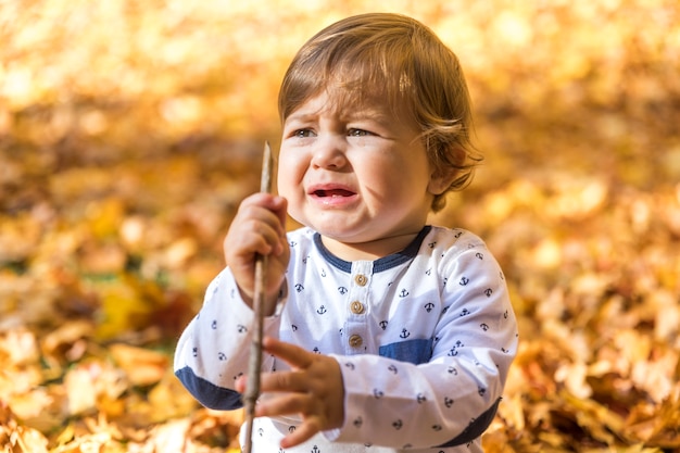 Medium shot crying baby with stick Free Photo