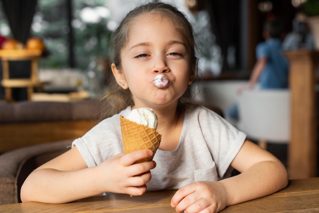 アイスクリームを食べるミディアムショットの女の子 無料の写真