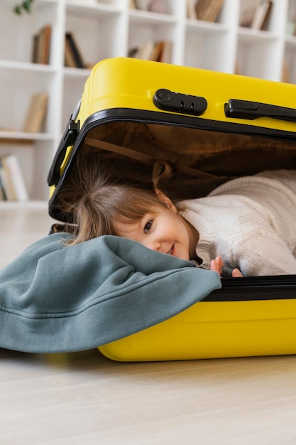 Free Photo | Medium shot girl sitting in luggage