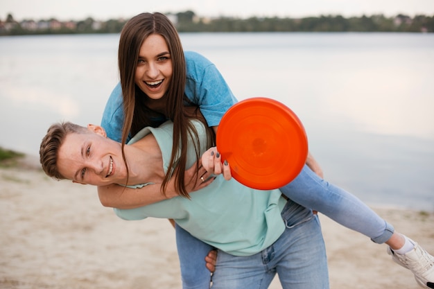 Medium Shot Happy Friends Fooling Around With Frisbee Photo Free Download 