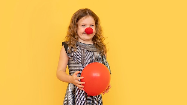 ピエロの鼻をかぶったミディアムショットの少女 無料の写真