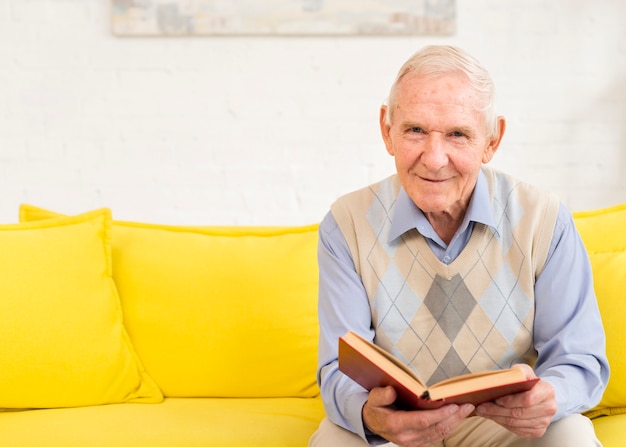 Medium shot old man reading a book Free Photo