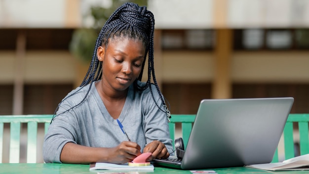 Medium shot student studying with laptop Free Photo