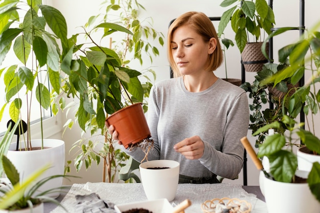 Free Photo | Medium shot woman holding plant pot