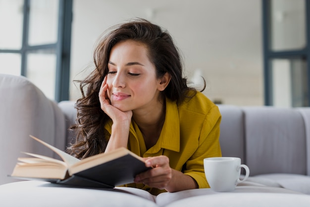 Medium shot woman with book and cup Free Photo