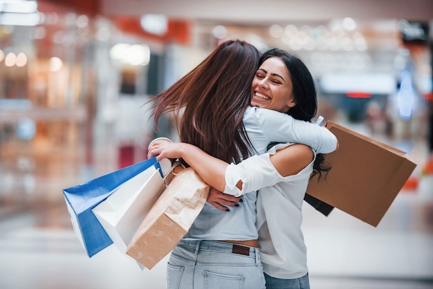 Premium Photo | Meeting of two female friends in the mall at weekend ...