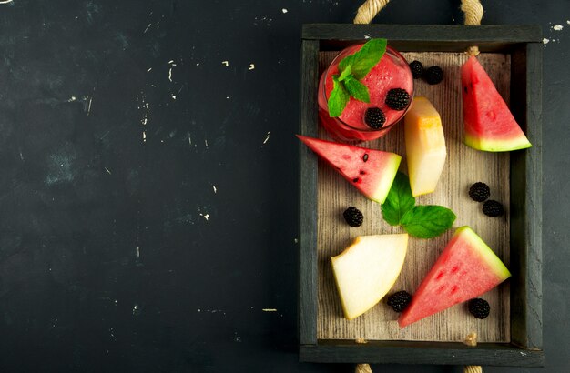 Melon, watermelon, blackberries and mint on a tray Premium Photo
