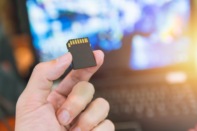 Memory card sd digital data storage with computer blur background Premium Photo