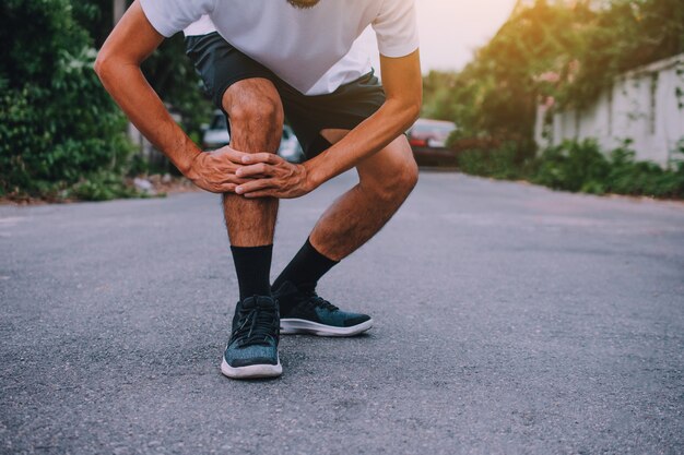 Premium Photo | Men with knee pain while jogging