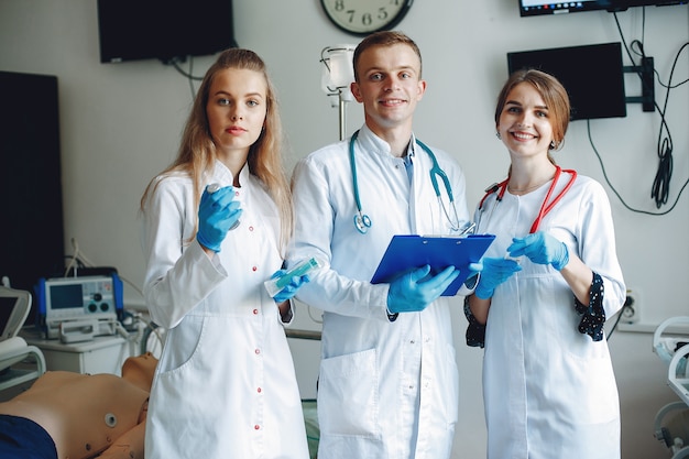 Men and women in hospital gowns hold medical equipment in their hands. Free Photo