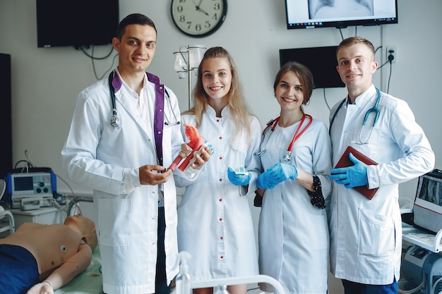 Free Photo | Men and women in hospital gowns hold medical equipment in their hands.