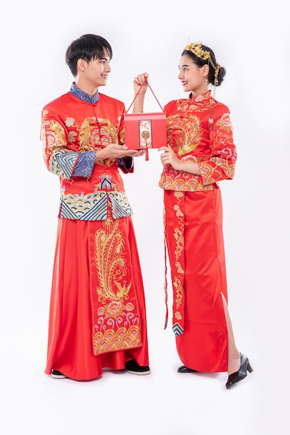 Free Photo  Men and women wearing cheongsam standing with red bags