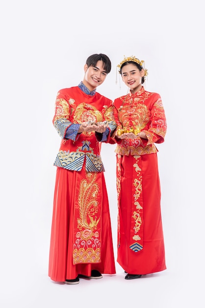 Free Photo  Men and women wearing qipao spend gold money